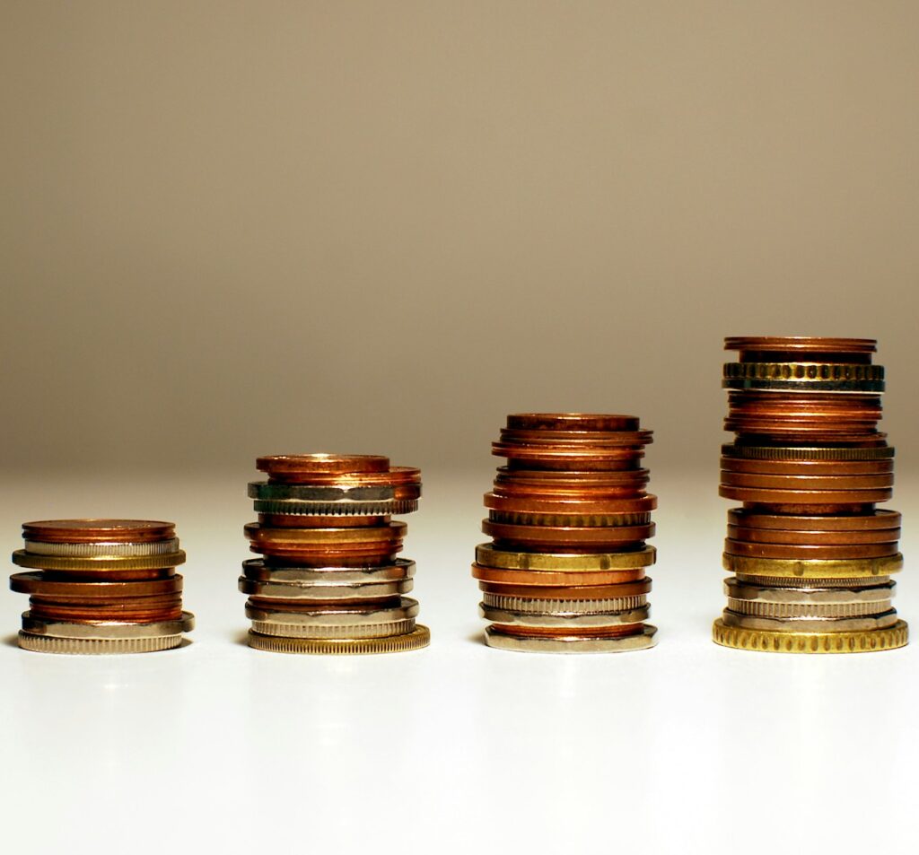 Aufgeteilte und wachsende Münzstapel – Geld sinnvoll aufteilen und investieren